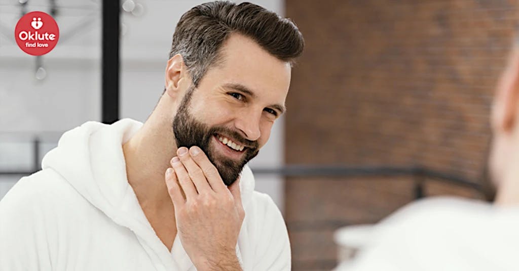 Imagen de hombre con barba en bata y sonriendo